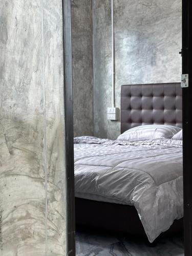 a bedroom with a bed with a leather headboard at DHome and Gardens in Phibun Mangsahan
