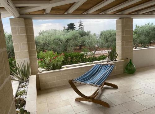 a hammock on a patio with a view of a garden at Dimora Ulivo in Impalata