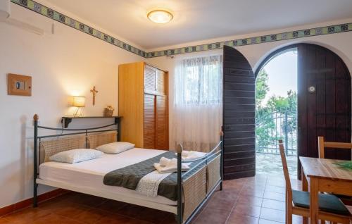 una camera da letto con un letto, un tavolo e una finestra di Villa Stavros by Villas Guide a Blato