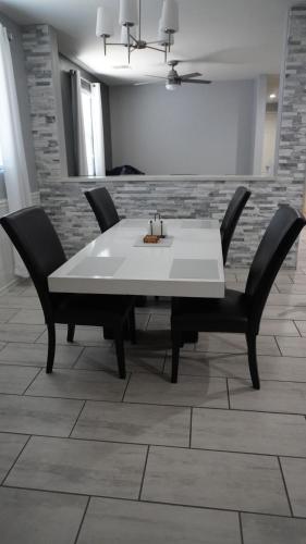 a dining room table with black chairs and a white table at Lovely white grey home 3 bedrooms in Buckeye