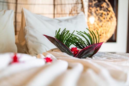 a white bed with a plant on top of it at Protea Hotel by Marriott Zambezi River Lodge in Katima Mulilo