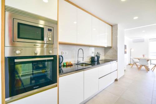 a kitchen with a microwave and a stove at Casa Ivo OceanView in Portimão