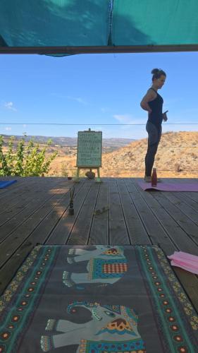 a woman is doing yoga on the beach at Yurts in Cyprus - Koliba Tiny House in Simou
