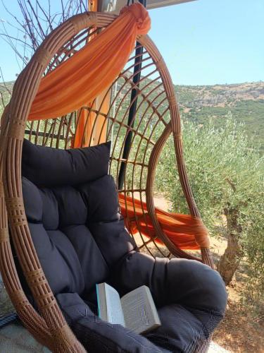 a swing with a pillow and books on it at Elaia Rest House Retreat in nature in Fréngaina