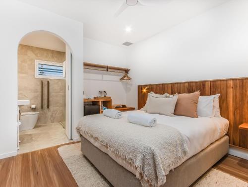 Un dormitorio con una cama grande y un baño. en The Health Lodge, en Byron Bay