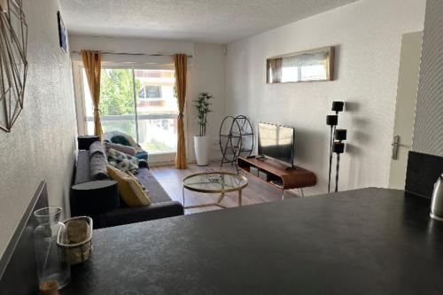 un salon avec un canapé et une table dans l'établissement Family apartment - near beach, à Arcachon