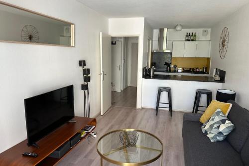 un salon avec un canapé et une table en verre dans l'établissement Family apartment - near beach, à Arcachon