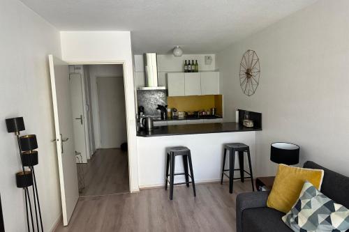 un salon avec un canapé et une cuisine dans l'établissement Family apartment - near beach, à Arcachon