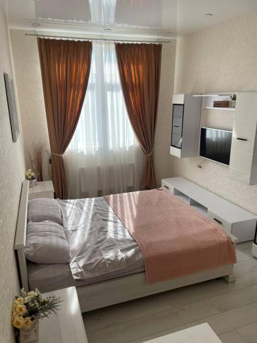 a bedroom with a large bed and a television at Апартаменти в АРКАДІЇ 10 хв до моря in Odesa