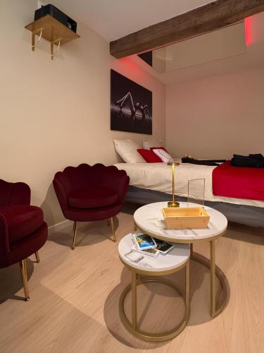 a room with two beds and a table and chairs at De Marbre et D or entre le futuroscope et le parc du Puy duFou in Boësse