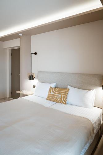 a large white bed with two pillows on it at Zante Sun Resort in Lithakia