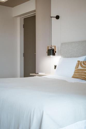 a white bed with a pillow on top of it at Zante Sun Resort in Lithakia