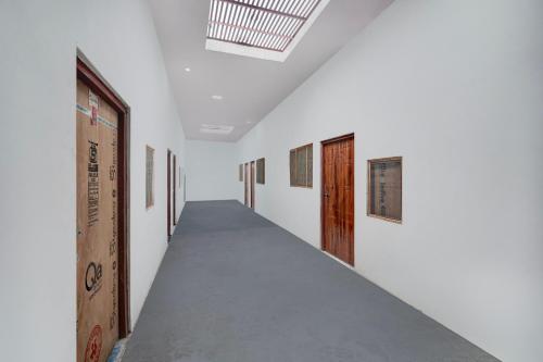 SītāpurSPOT ON Rs Hotel的一间白墙木门房间的走廊