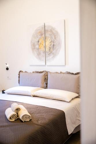 a bedroom with a bed with two towels on it at Carlo's House in Bosa