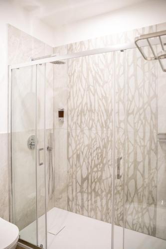 a bathroom with a shower with a glass door at Carlo's House in Bosa