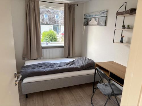 a bedroom with a bed and a desk and a window at Herning Nord - Tjørring B&B in Herning