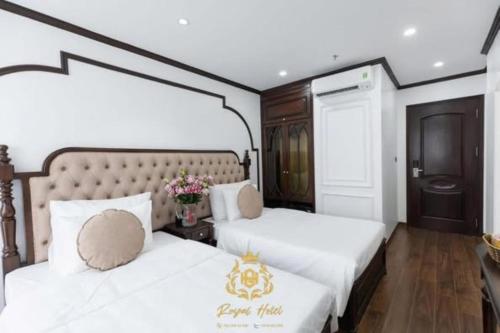 a bedroom with two beds with white sheets at Royal Hotel Kangnam in Hanoi
