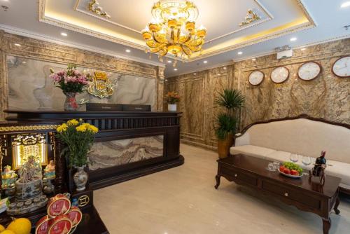 a living room with a fireplace and a chandelier at Royal Hotel Kangnam in Hanoi