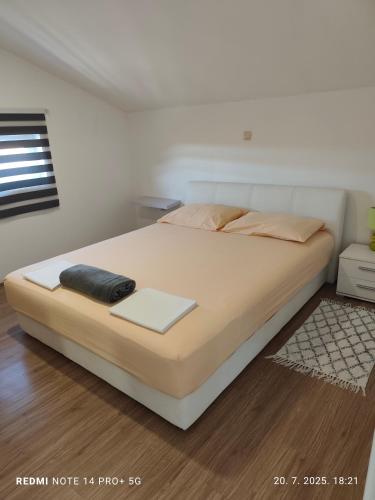 a bedroom with a large bed with a white mattress at Apartmani Bezek in Ston
