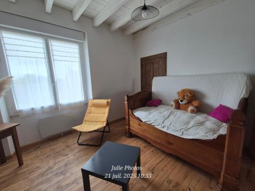 a teddy bear sitting on a bed in a room at Maison spacieuse 8 couchages proche cascade lac et base de loisirs et de bien être in Lacaze