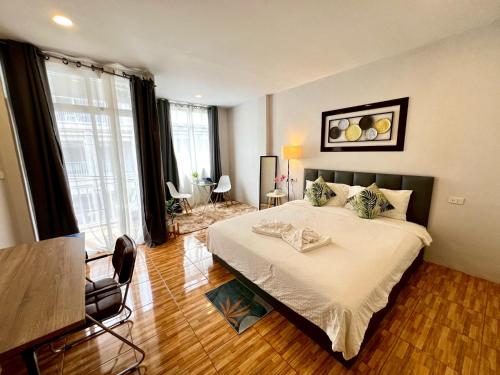 a bedroom with a large bed and a table at Mama's Cozy Studio - Patong Beach in Patong Beach