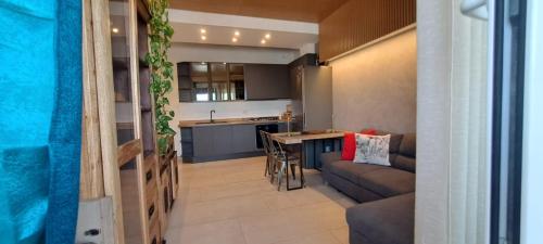 a kitchen and living room with a couch and a table at FORMIAE Hsg - PANORAMICA CENTRALE Casa Vacanze 100mq BOX Auto riservato in Formia