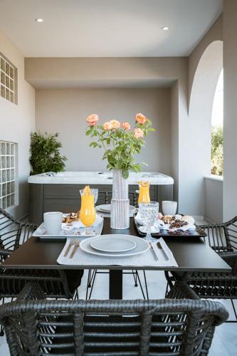 a dining room table with a vase of flowers on it at Zante Sun Resort in Lithakia