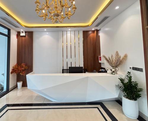 a reception desk in a lobby with a chandelier at Mer Suites Ha Long in Ha Long