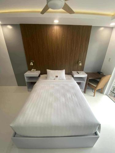 a bedroom with a large white bed and two tables at Buena Casa Hotel in Olongapo
