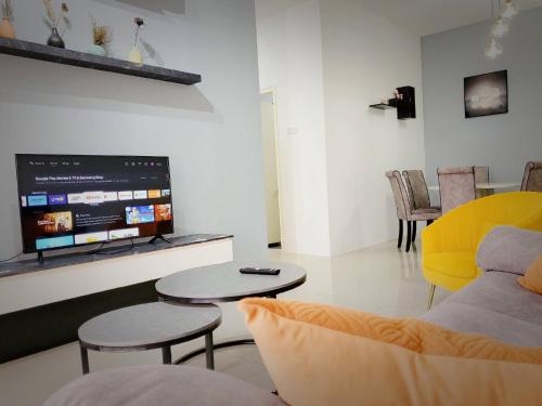 a living room with a couch and a tv at Ipoh Cove Hillside Mini Waterpark Family Suite in Ipoh