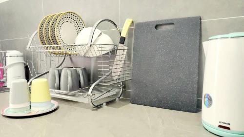 a dish drying rack in a kitchen with dishes at Ipoh Cove Hillside Mini Waterpark Family Suite in Ipoh