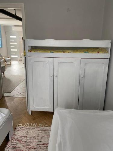 a white crib in a room with a bed at Napsugár vendégház in Mezőkövesd