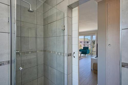 a bathroom with a shower with a glass door at 61 Big Bay Beach Club in Cape Town