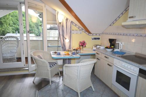 a kitchen with a table and chairs and a kitchen with a window at Villa Strandperle, App 18 - nur 20m zum Strand, TOPLAGE in Binz