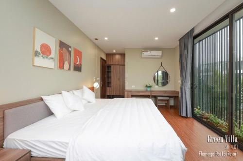 a bedroom with a white bed and a large window at Green Villa 5 phòng ngủ ở Flamingo Đại Lải Resort in Phúc Yên