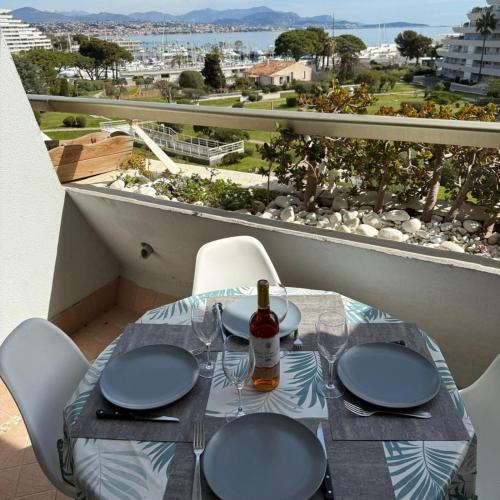 - une table avec des verres et une bouteille de vin sur le balcon dans l'établissement Appartement Vue sur la mer à 5 minutes des plages, à Villeneuve-Loubet