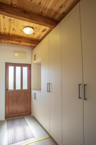 a room with white cabinets and a wooden door at House Maša in Žabljak