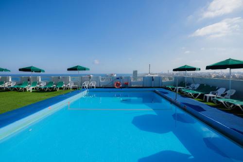 a large swimming pool on the roof of a building at Grand Beach Hotel in Tel Aviv