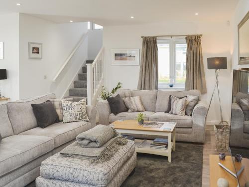 ein Wohnzimmer mit Sofa und Tisch in der Unterkunft Dune View in Beadnell