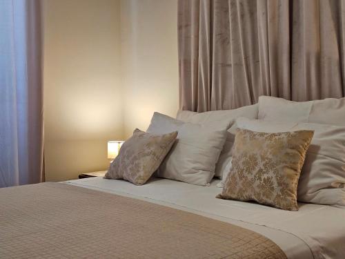 a large bed with white pillows at Family Apartments Suzi in Rovinj