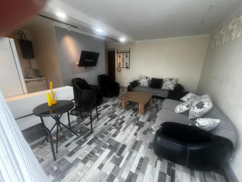 Una sala de estar con un sofá y sillas y una mesa. en Nina Home, 