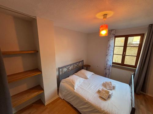 una camera da letto con un letto bianco e una finestra di Le Sadal a La Celle-sous-Gouzon