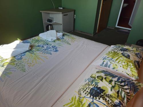 a bedroom with a bed with towels on it at Family hotel Favourite in Obzor