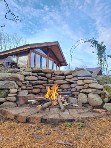 a fire pit in front of a stone wall at Studio Belvedere in Mălăeşti