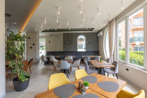 a restaurant with tables and chairs and windows at Hotel Sea Sand in Sveti Vlas
