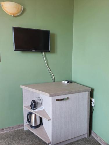 a room with a desk with a tv on a wall at Family hotel Favourite in Obzor