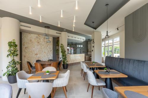 a restaurant with wooden tables and white chairs at Hotel Sea Sand in Sveti Vlas
