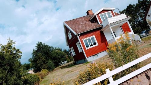 a red house on a hill with a white fence at Rotes Småland - Haus, Schweden, ideal für Familien, See in der Nähe in Silverdalen