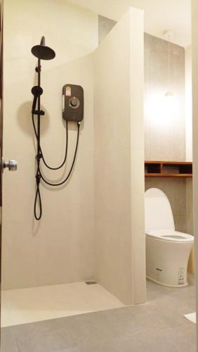 a bathroom with a toilet and a light on the wall at Baan Varintorn Suanphueng in Suan Phung
