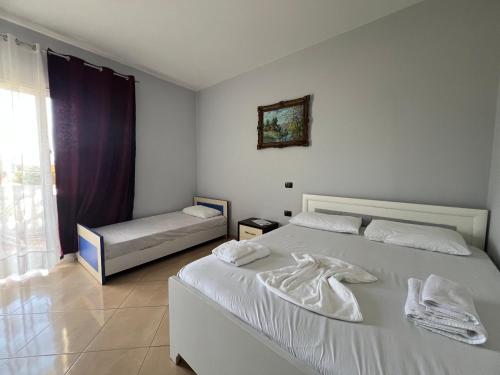 una camera da letto bianca con un letto e una finestra di Vila Olti a Vlorë